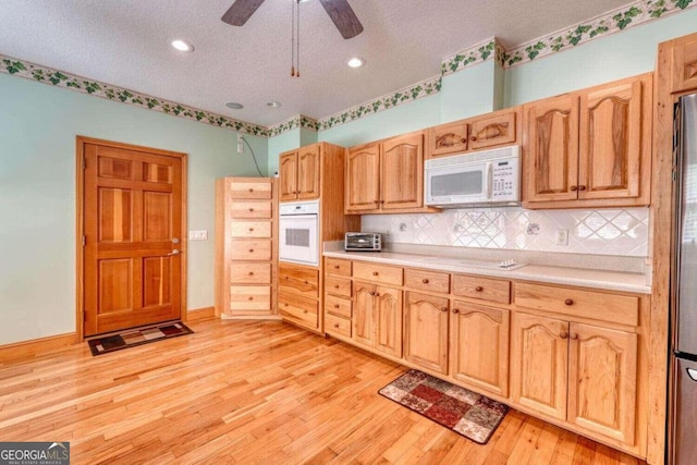 kitchen featuring ceiling fan, white appliances, a textured ceiling, and light hardwood / wood-style floors