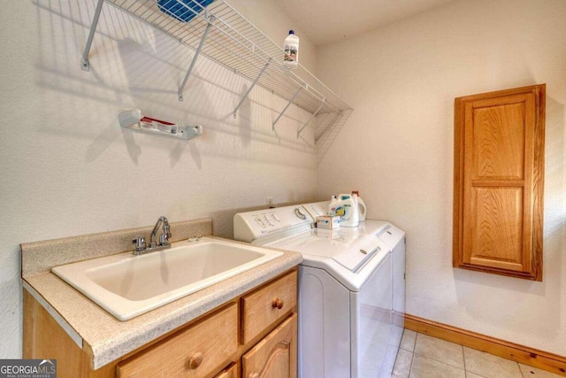 laundry room featuring independent washer and dryer, light tile patterned floors, and sink