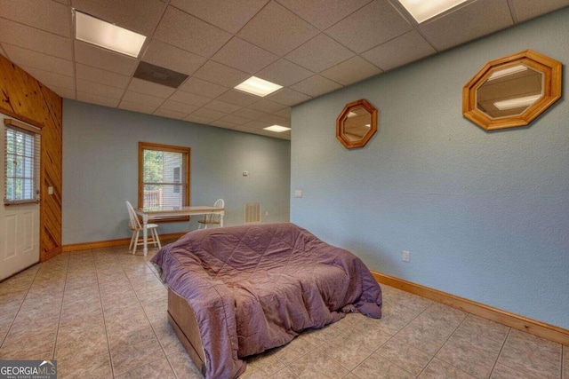 bedroom featuring a paneled ceiling and tile patterned floors