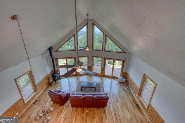 living room featuring light hardwood / wood-style flooring, high vaulted ceiling, ceiling fan, and a wealth of natural light