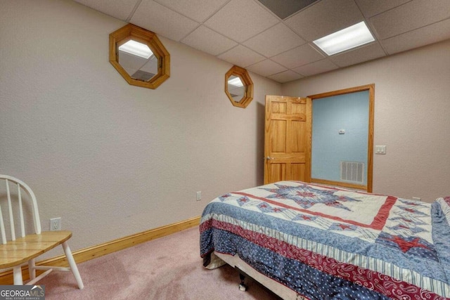 carpeted bedroom with a paneled ceiling