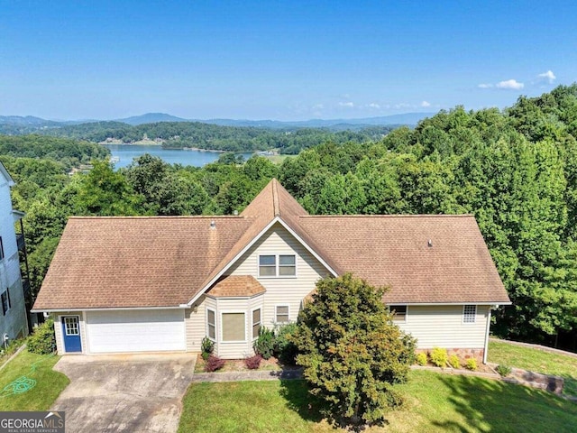 view of front of house with a front yard, a water view, and a garage