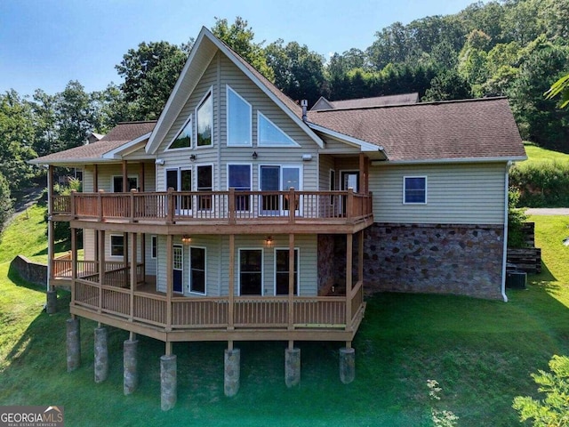 rear view of property featuring a wooden deck and a yard