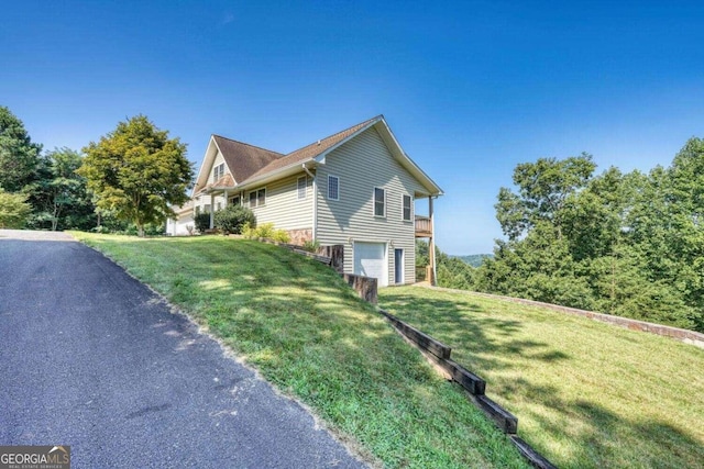 view of home's exterior featuring a garage and a lawn