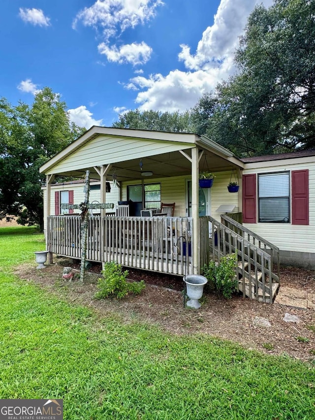 manufactured / mobile home with a front yard and covered porch