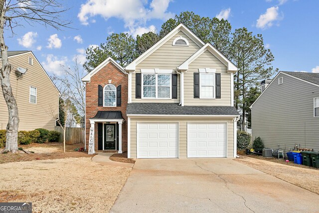 front facade with a front yard, cooling unit, and a garage