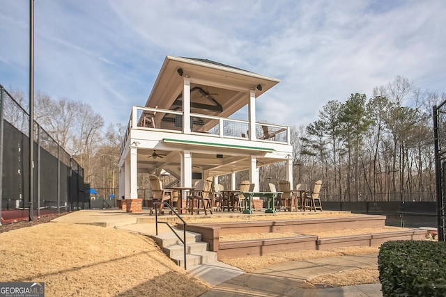 view of front of house featuring ceiling fan and a balcony