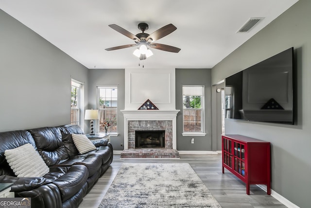 living room with ceiling fan, hardwood / wood-style floors, and a fireplace