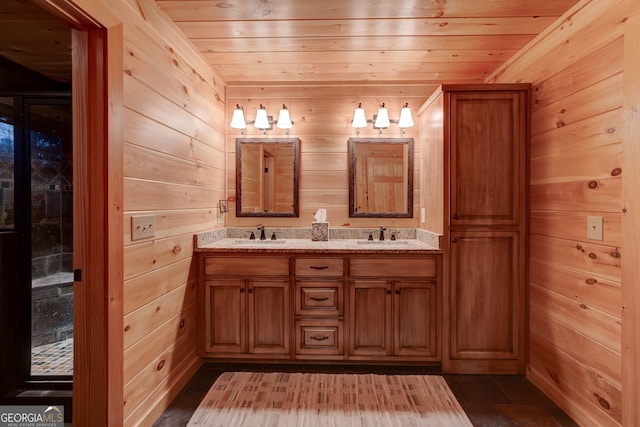 bathroom with dual bowl vanity, wooden walls, hardwood / wood-style flooring, and wood ceiling