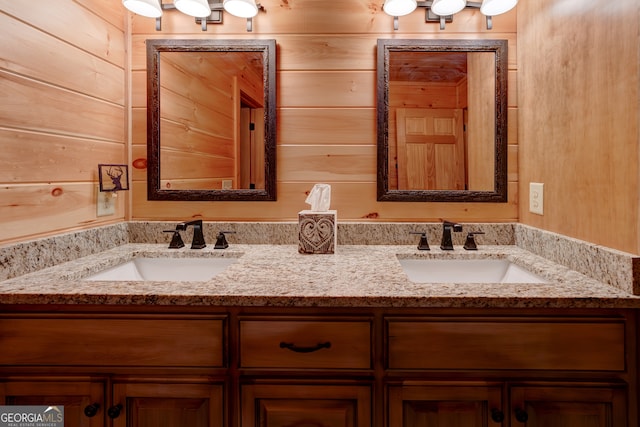 bathroom featuring double vanity and wooden walls