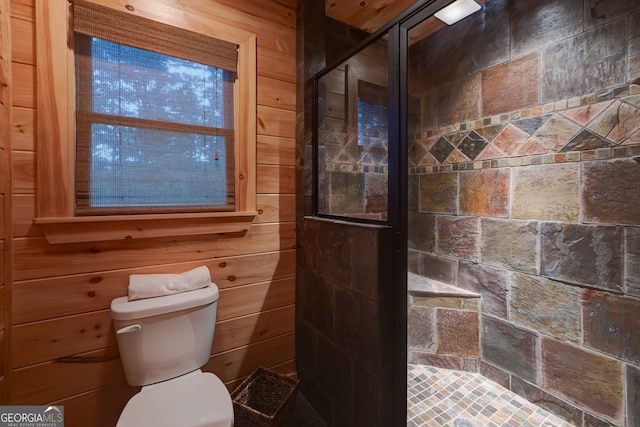 bathroom with a shower with door, wooden walls, and toilet