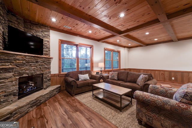 living room with beam ceiling, a fireplace, wooden ceiling, and light hardwood / wood-style floors