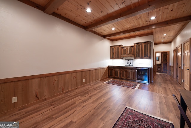 kitchen with wine cooler, dark brown cabinets, beamed ceiling, hardwood / wood-style floors, and wood ceiling