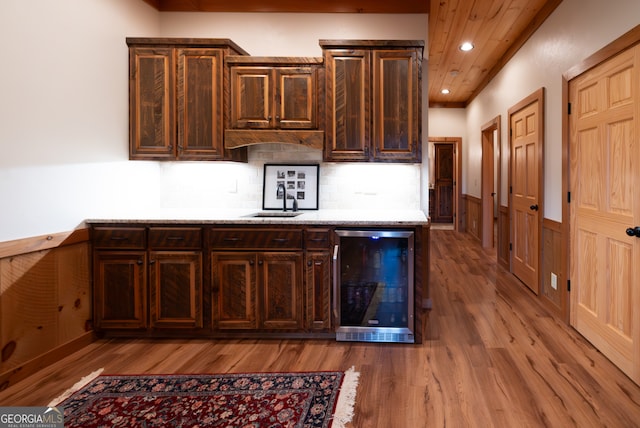 kitchen featuring decorative backsplash, dark brown cabinets, light wood-type flooring, wine cooler, and sink