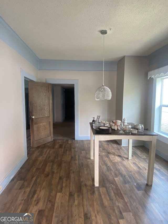 dining space with a textured ceiling and hardwood / wood-style flooring