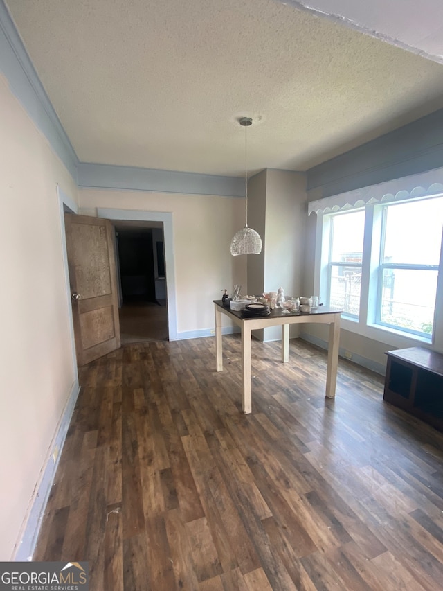 unfurnished dining area featuring a textured ceiling and wood-type flooring