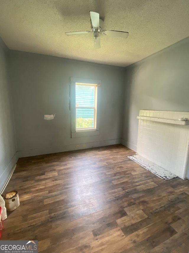 unfurnished room with ceiling fan, a textured ceiling, and hardwood / wood-style flooring