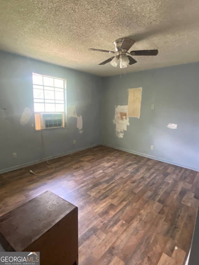 spare room with ceiling fan, a textured ceiling, cooling unit, and wood-type flooring