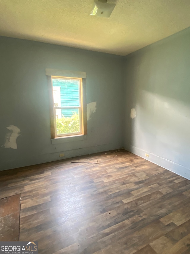 unfurnished room featuring a textured ceiling and hardwood / wood-style flooring