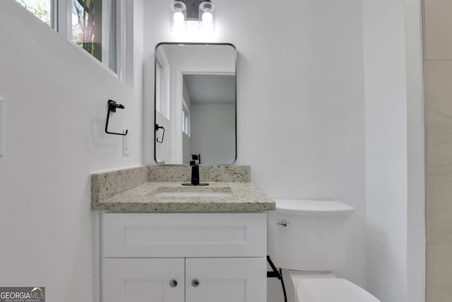 bathroom featuring toilet and vanity