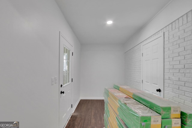 interior space featuring dark hardwood / wood-style floors and brick wall