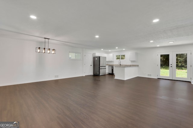 unfurnished living room featuring french doors, dark hardwood / wood-style floors, and sink