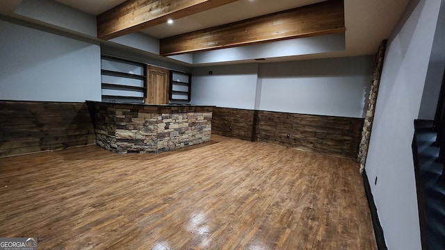 bar with wood-type flooring, wooden walls, and beamed ceiling