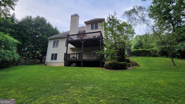 back of property featuring a deck and a yard