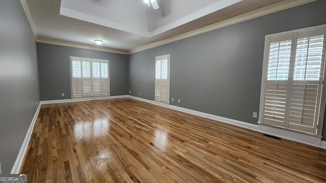 spare room featuring crown molding, wood-type flooring, and ceiling fan