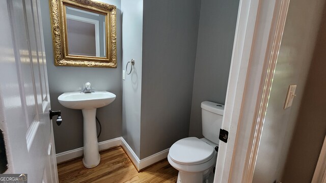 bathroom featuring hardwood / wood-style flooring and toilet