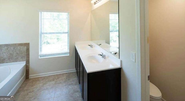 bathroom featuring a healthy amount of sunlight, toilet, a bath, and tile patterned flooring