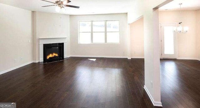 unfurnished living room with dark hardwood / wood-style flooring and ceiling fan with notable chandelier