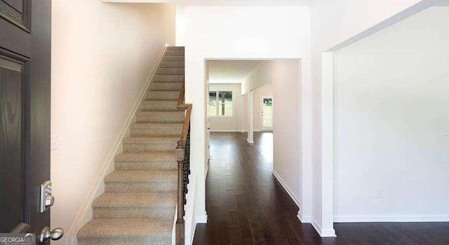 stairs featuring dark wood-type flooring