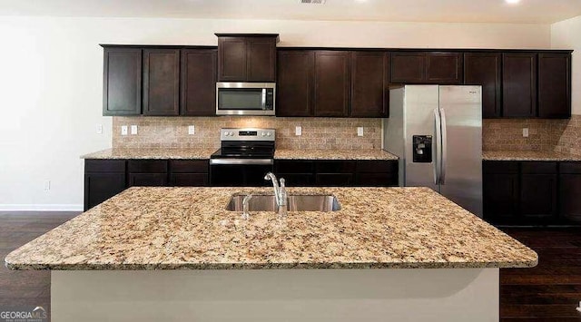 kitchen featuring sink, dark hardwood / wood-style flooring, stainless steel appliances, and a kitchen island with sink