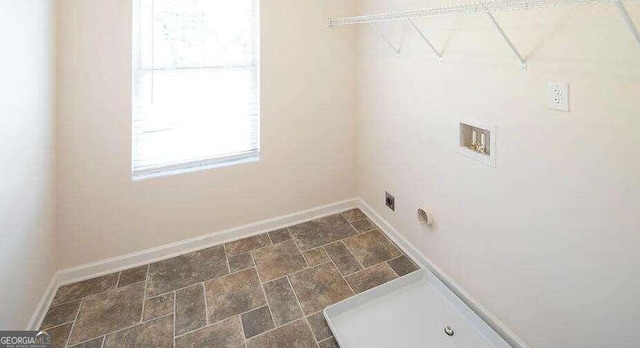 clothes washing area with dark tile patterned flooring, hookup for an electric dryer, and washer hookup