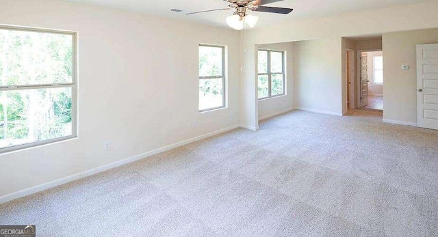 unfurnished bedroom featuring ceiling fan, light carpet, and multiple windows