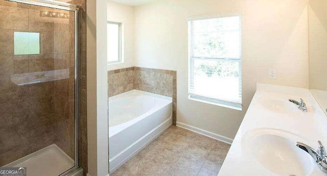 bathroom with double vanity, plenty of natural light, and plus walk in shower