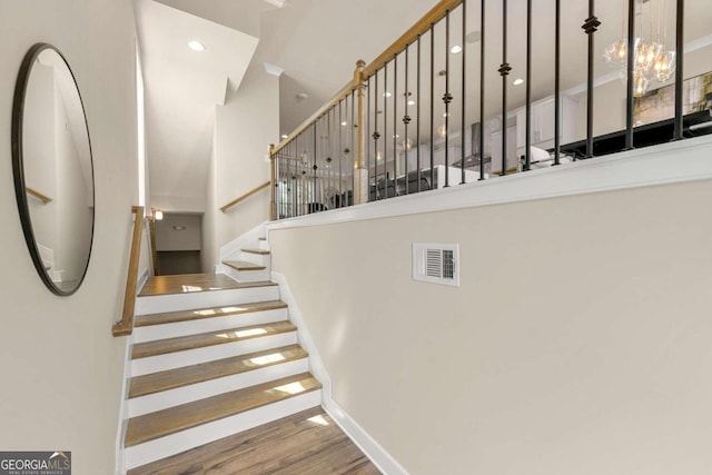 stairs with a towering ceiling and hardwood / wood-style floors