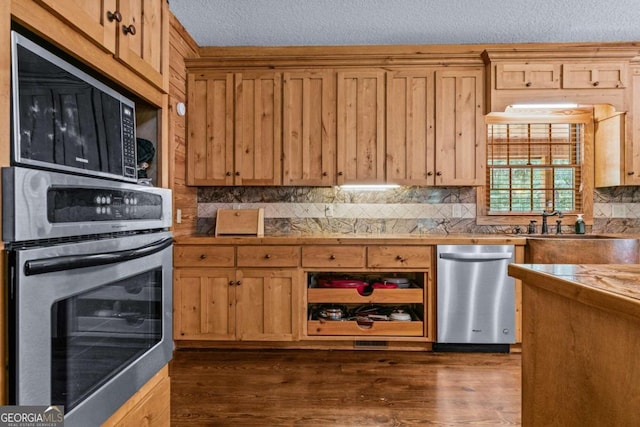 225 Big Oconee River Rd, Sparta, GA 31087 - kitchen with a textured ceiling, appliances with stainless steel finishes, decorative backsplash, and dark wood-style flooring