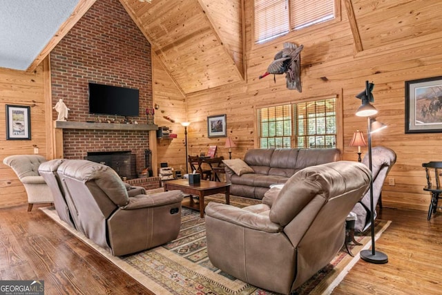 225 Big Oconee River Rd, Sparta, GA 31087 - living area with wood walls, a fireplace, high vaulted ceiling, and wood finished floors
