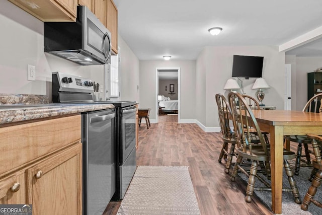 225 Big Oconee River Rd, Sparta, GA 31087 - kitchen featuring stainless steel appliances, light countertops, light brown cabinetry, wood finished floors, and baseboards