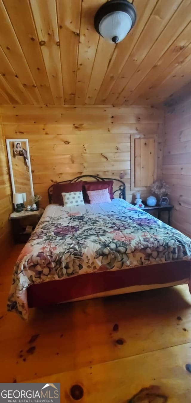 bedroom with wood walls and wooden ceiling