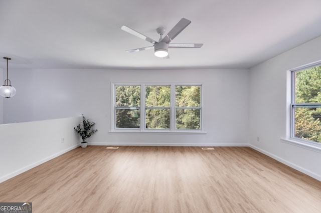 unfurnished room with ceiling fan, a wealth of natural light, and light hardwood / wood-style floors