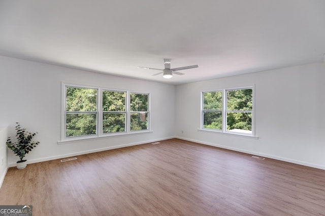 empty room with ceiling fan and hardwood / wood-style flooring