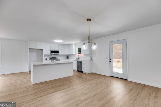 kitchen featuring white cabinetry, pendant lighting, a center island, light hardwood / wood-style floors, and stainless steel appliances