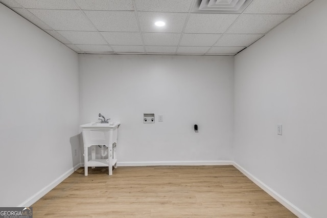 clothes washing area with light hardwood / wood-style flooring and hookup for a washing machine