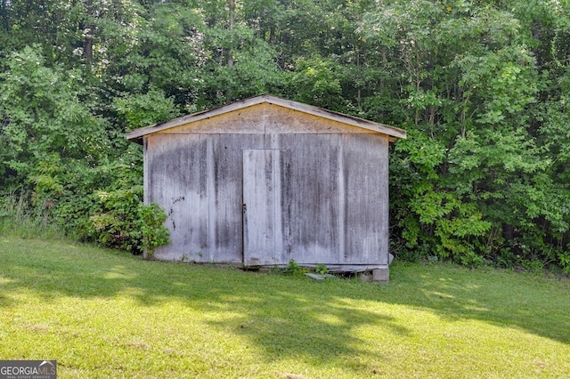 view of outbuilding with a yard