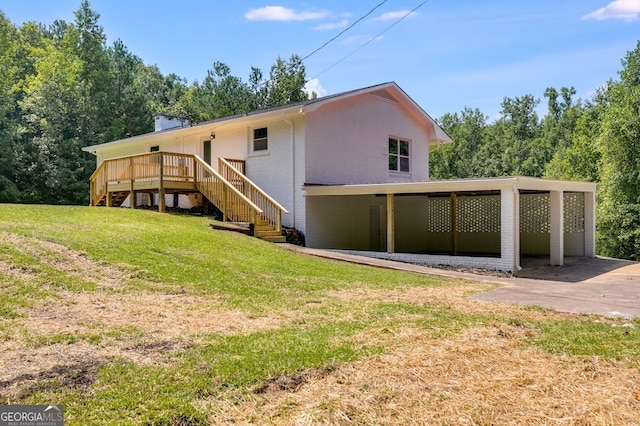 back of house with a yard, a carport, and a wooden deck