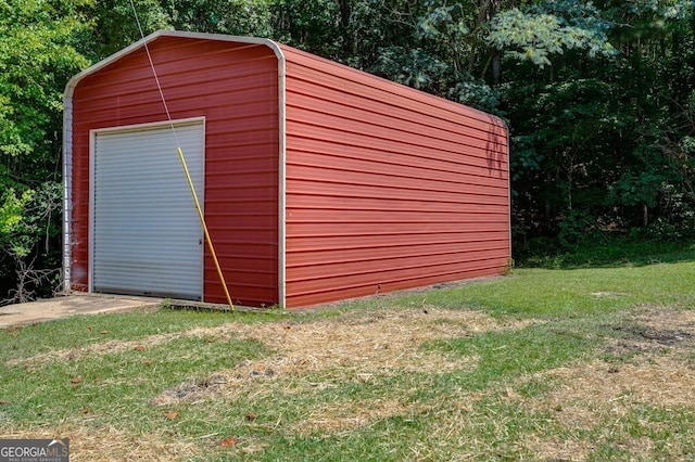 view of outdoor structure with a yard and a garage