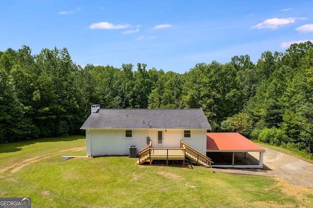 back of property with central AC, a wooden deck, a carport, and a lawn